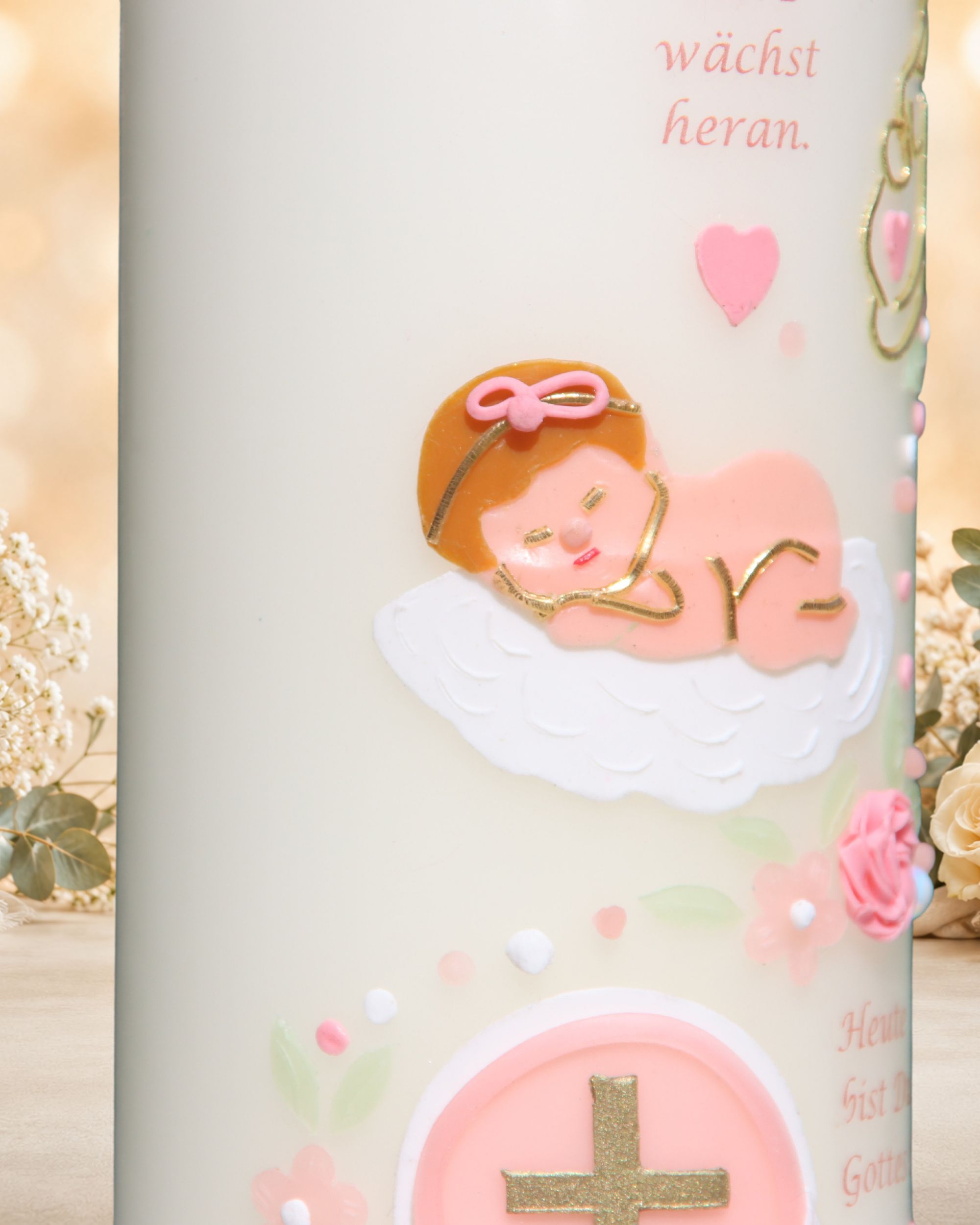 Detail der Taufkerze Elena mit plastischer Wachsverzierung: Baby auf Decke, Kreuz, Rose, Herzen und Blüten