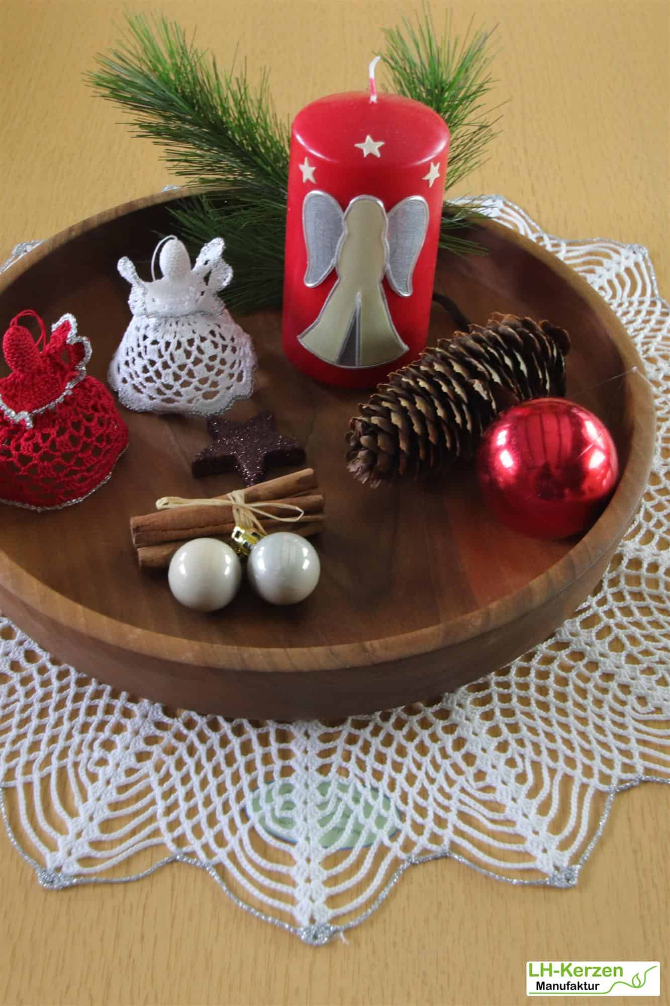 Rote Weihnachtskerze mit stehendem Engel