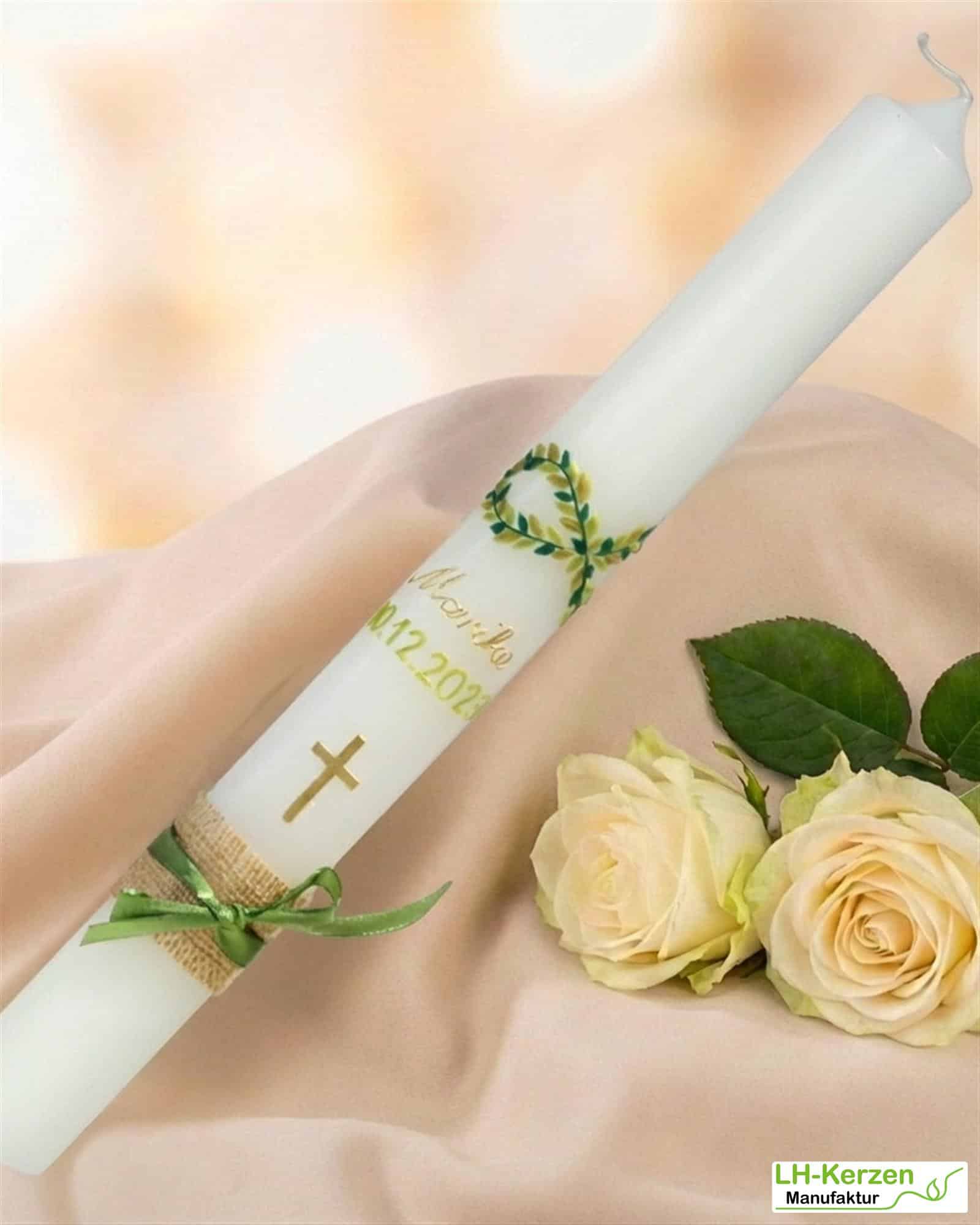 Schlanke Taufkerze mit zu einem Fisch geformter grüner Blattranke und goldenem Kreuz