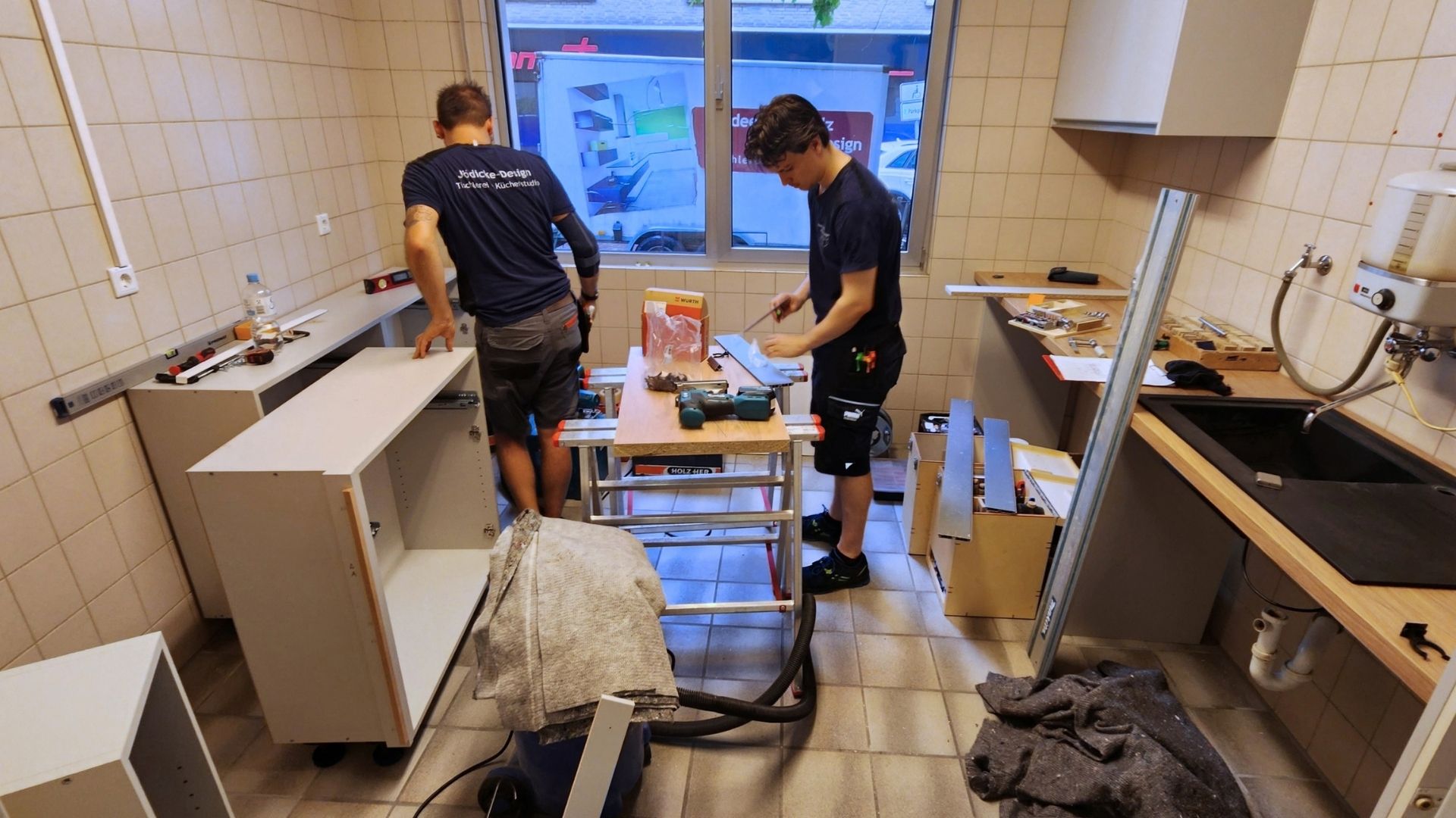 Zwei Handwerker montieren Möbel und Arbeitsflächen in der künftigen Kerzengießerei