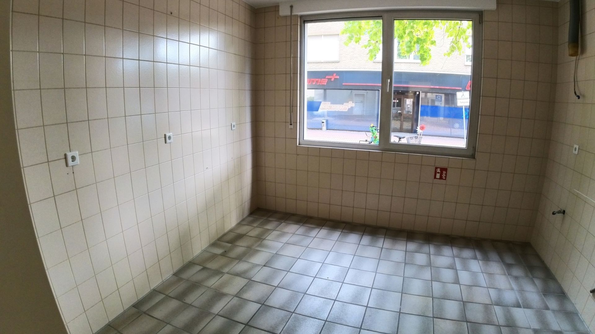 Leerer, weiß gefliester Raum mit Fenster vor dem Ausbau zur Kerzengießerei